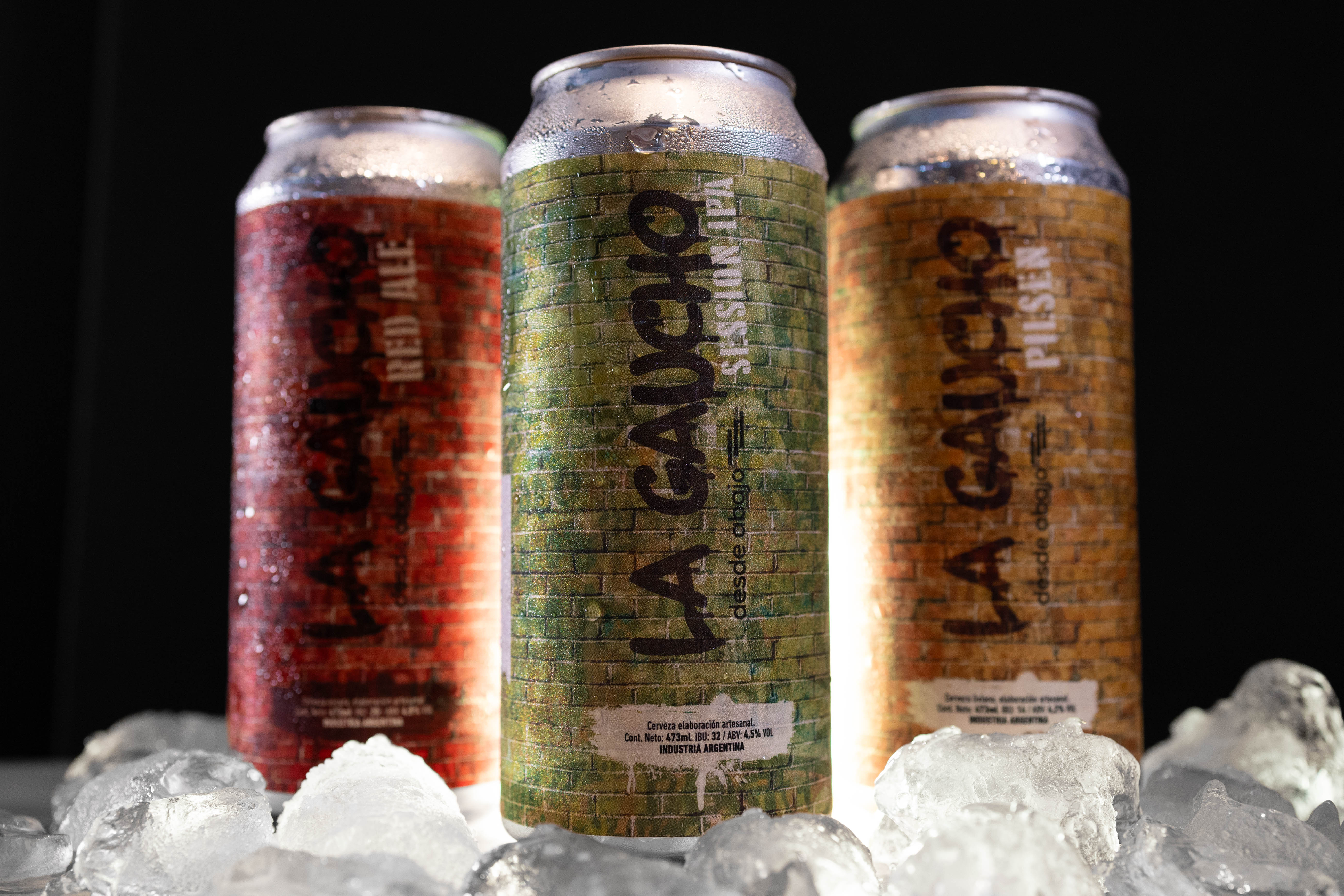 Tres latas de Birra La Gaucho: Red Ale, Session IPA y Pilsen sobre hielo